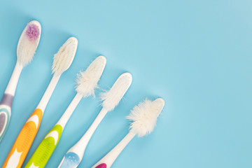 The old toothbrush used expired (damaged) variety of colors on the blue background. concept Used for manufacturing health industry Professional dentist or often should change your toothbrush. 