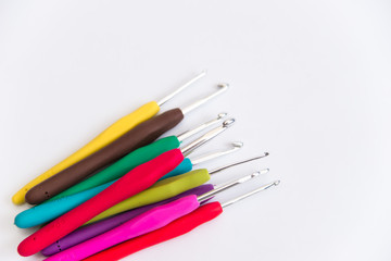 colored crochet hooks on white background