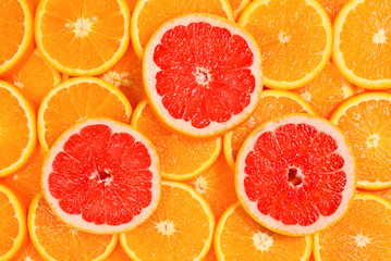 Slices of oranges and a grapefruits as a background.