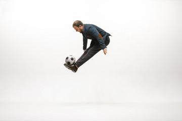 Fototapeta na wymiar Businessman with football ball in office. Soccer freestyle. Concept of balance and agility in business. Manager perfoming tricks isolated on white studio background.