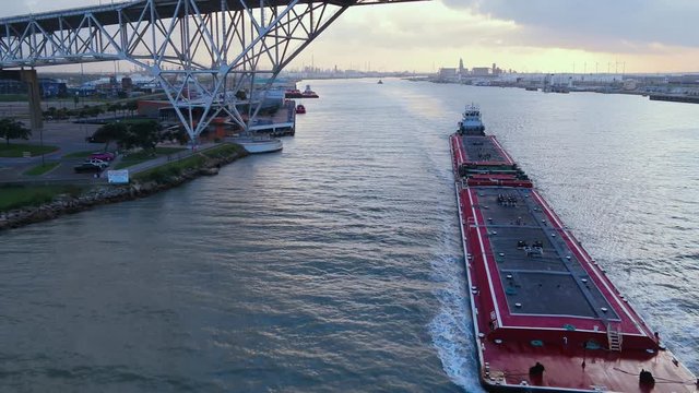 working barge heading out of port under the corpus Christi bridge sunset in the back drop