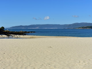 Beach with bright sand, seagulls and blue sky. Galicia, Spain.