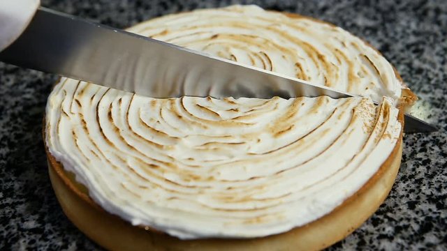 human hand cut in half homemade lemon cake by knife