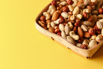 Dried fruits and nuts mix in a wooden bowl. 