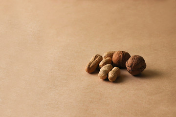 Hazelnuts, cashews, peanuts, walnuts, almonds, seeds lie on a beige background. 
