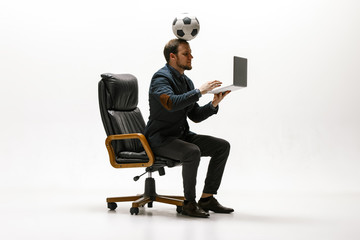 Businessman with football ball in office. Soccer freestyle. Concept of balance and agility in...