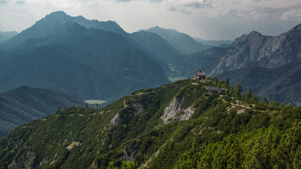 Fototapeta na wymiar mountain cabin on peak with tree covered mountain