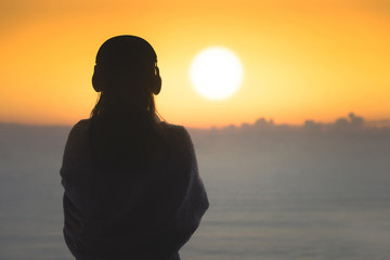 Silhouette of naked woman with wet hair wrapped in a blanket after swimming. Female in the...