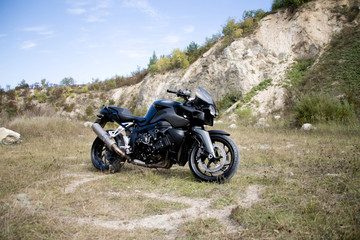 Obraz premium The motorcycle stands at the background of a career in the summer