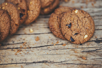 Close up of a group Chocolate chip cookies many stacked on dark old rustic wooden plank table with Leave Copy space place for text. freshly baked. Selective Focus.