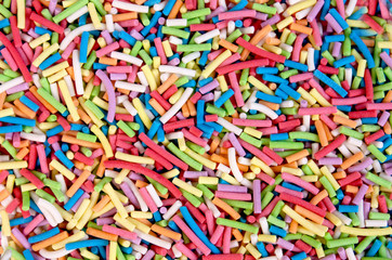 Fototapeta na wymiar Colorful sweet background with colorful sprinkles. Cupcake and Ice cream topping. Sweet Texture. Sweet Background