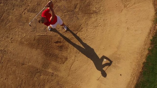 A golfer stuck in a sand trap cannot hit the ball out.