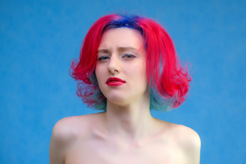 High fashion model woman with multi-colored hair posing in the studio, portrait of a beautiful sexy girl with a fashionable makeup and manicure.