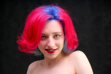 High fashion model woman with multi-colored hair posing in studio, portrait of beautiful sexy girl with a fashionable makeup and manicure.