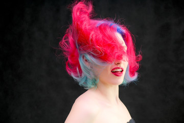 High fashion model woman with multi-colored hair posing in studio, portrait of beautiful sexy girl with a fashionable makeup and manicure.