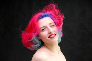 High fashion model woman with multi-colored hair posing in studio, portrait of beautiful sexy girl with a fashionable makeup and manicure.