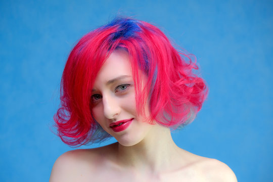 High fashion model woman with multi-colored hair posing in the studio, portrait of a beautiful sexy girl with a fashionable makeup and manicure.