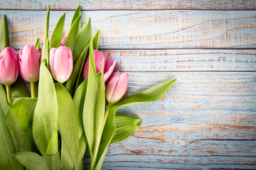 Różowe tulipany na drewnianym tle