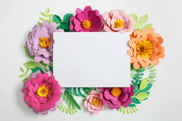 Foto op Canvas top view of white blank card on multicolored paper flowers with green leaves on grey background © LIGHTFIELD STUDIOS