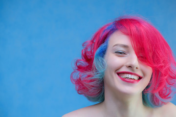 High fashion model woman with multi-colored hair posing in the studio, portrait of a beautiful sexy girl with a fashionable makeup and manicure.