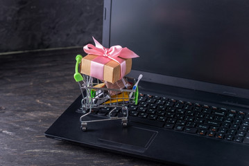 Daily purchases and gifts in the shopping cart on the laptop keyboard. Shopping in online stores