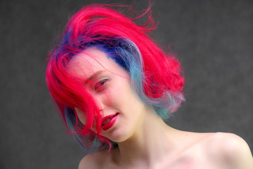 High fashion model woman with multi-colored hair posing in the studio, portrait of a beautiful sexy girl with a fashionable makeup.