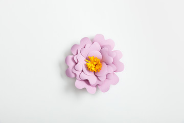 Fototapeta na wymiar top view of lilac paper flower on grey background