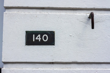 140 on a white house wall