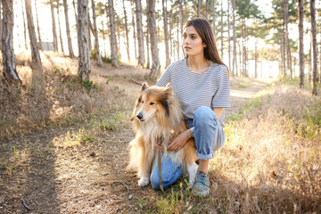 young beautiful woman walking with collie dog.