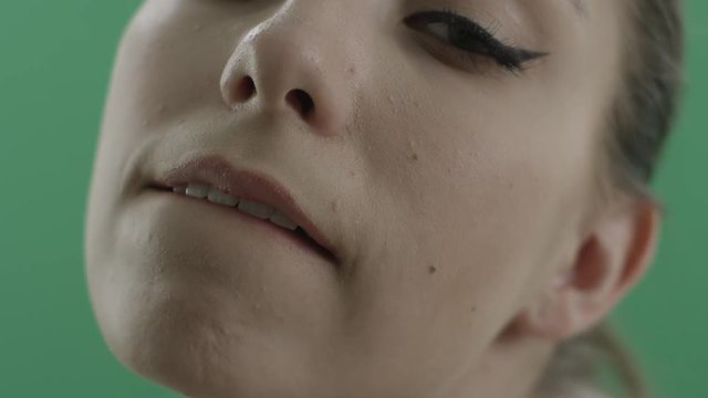 Sensual woman bites her lips against green background