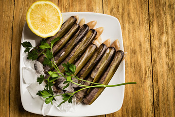 knives, parsley and half a lemon in white dishes with ice