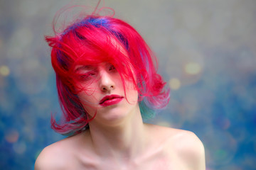 High fashion model woman with multi-colored hair posing in the studio, portrait of a beautiful sexy girl with a fashionable makeup