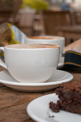 cup of coffee and chocolate brownie on wooden table