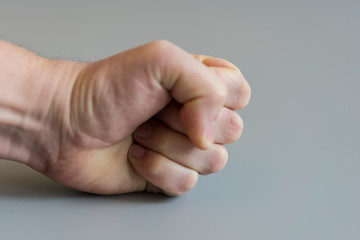 fist on gray background. The concept of domestic violence. Male rudeness and violence