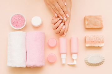 Hands beauty care. DIY treatment. Organized composition of assorted cosmetic products on coral pink...