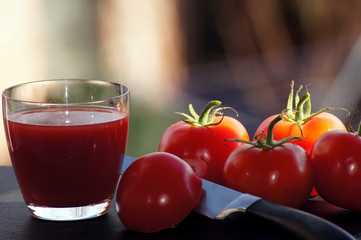 Rote Tomaten mit einem Glas Tomatensaft