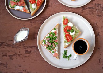 Light breakfast, assorted toasts with a variety of fillings on a white plate. op view.