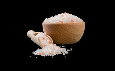 Himalayan pink salt in wooden bowl and scoop isolated on black background. Spices and food ingredients.