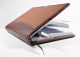 Business notebook with pen isolated on white background