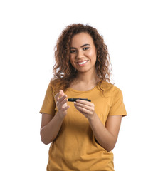 Young African-American woman using lancet pen on white background. Diabetes control