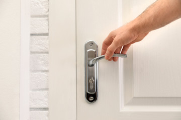 Man reaching to metal door handle, closeup