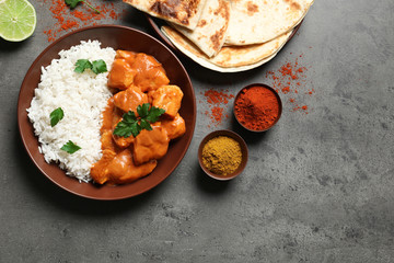 Butter chicken with rice served on grey table, flat lay. Space for text