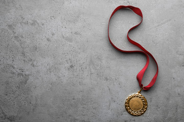 Gold medal with space for design on grey background, top view. Victory concept