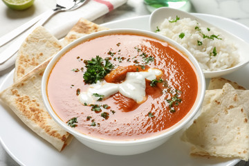 Delicious butter chicken in bowl served with rice on dish. Traditional Murgh Makhani dish
