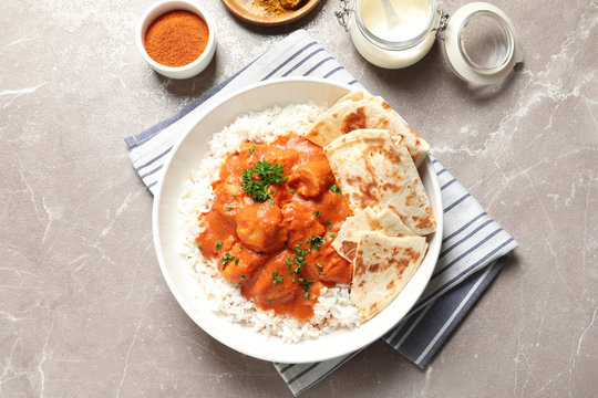 Delicious butter chicken with rice served on table, flat lay