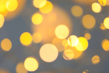 Blurred view of gold lights on dark background. Bokeh effect