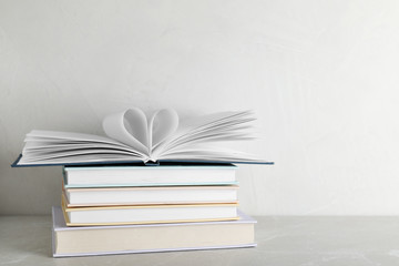 Stack of hardcover books on table against white background, space for text