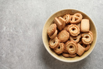 Bowl with Danish butter cookies on grey background, top view. Space for text