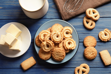 Plate with Danish butter cookies on wooden background, flat lay - obrazy, fototapety, plakaty