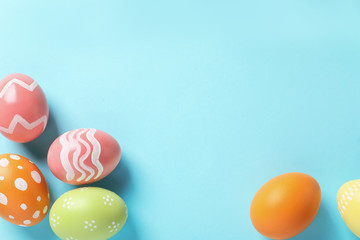 Flat lay composition of painted Easter eggs on color background, space for text
